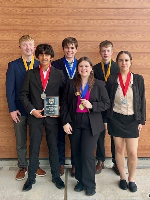 Tyler Legacy speech and debate posing with their medals and plaque