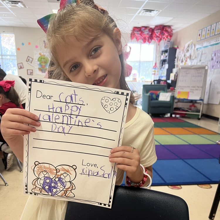 Student displaying valentines writing