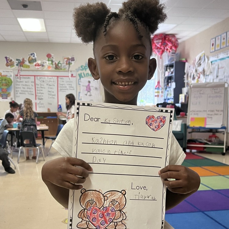 Student displaying valentines writing