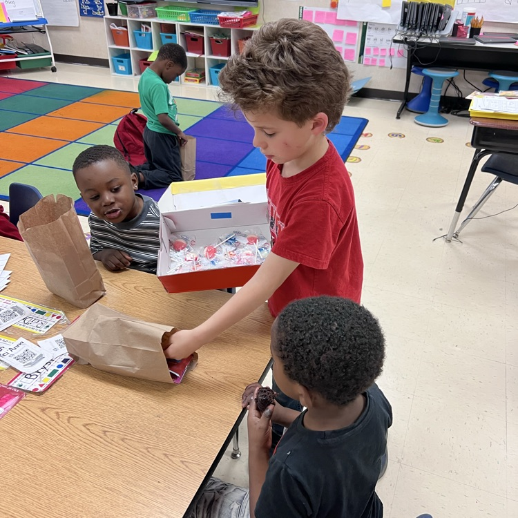 Students working on valentines writing at tables