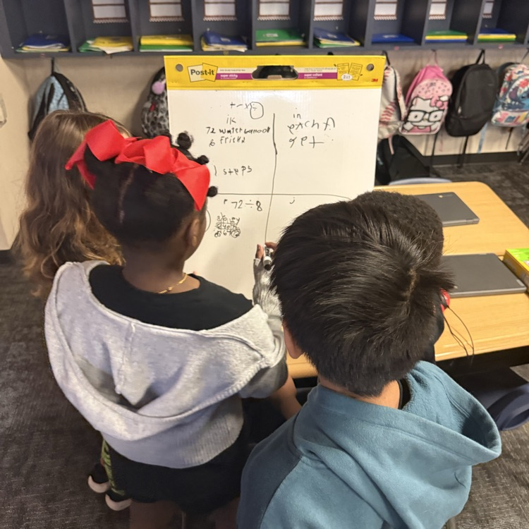 student s showing their math work on a vertical board