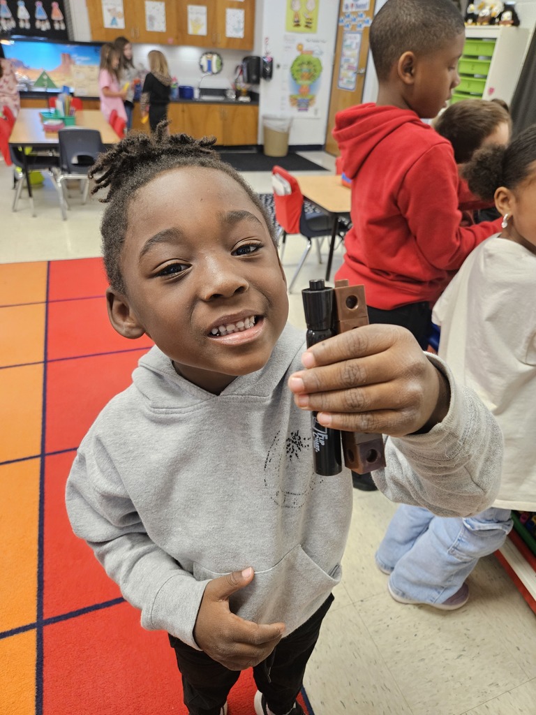 Kindergarten students using blocks to measure classroom items.
