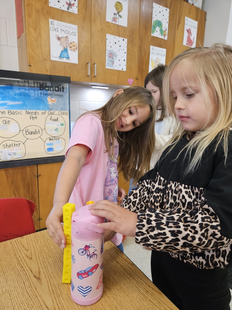 Kindergarten students using blocks to measure classroom items.