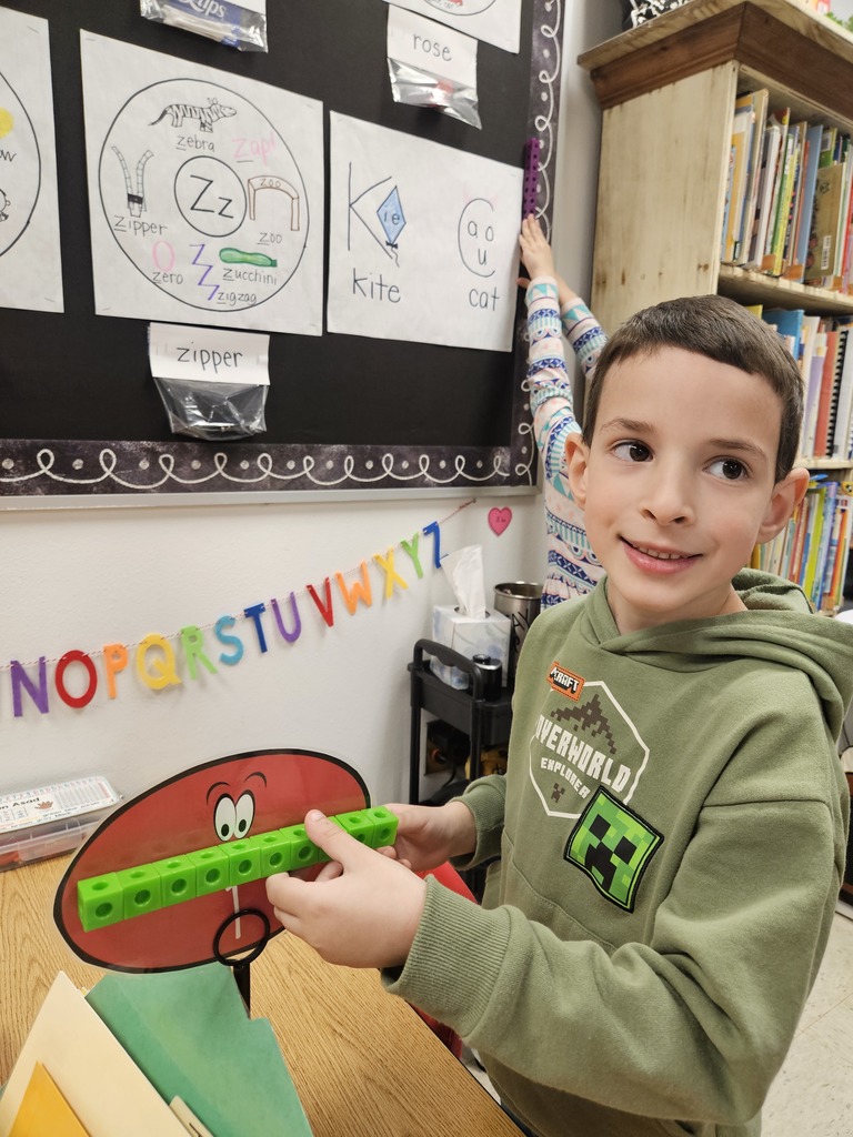 Kindergarten students using blocks to measure classroom items.