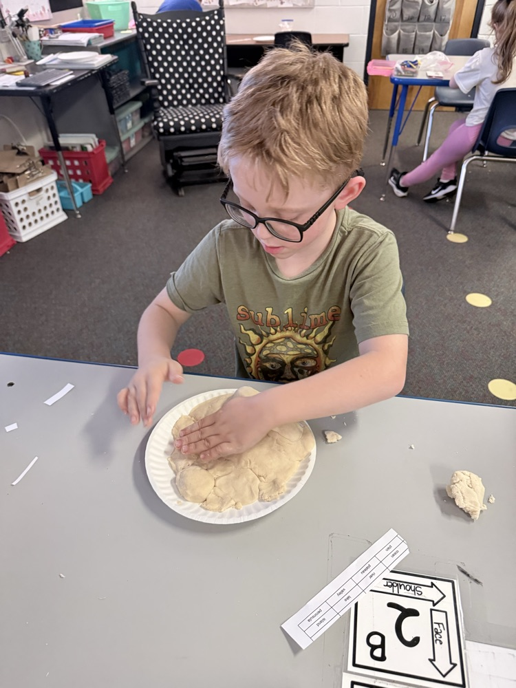 students showing off salt dough landforms 