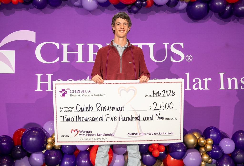 Caleb Roseman holding his check for his scholarship