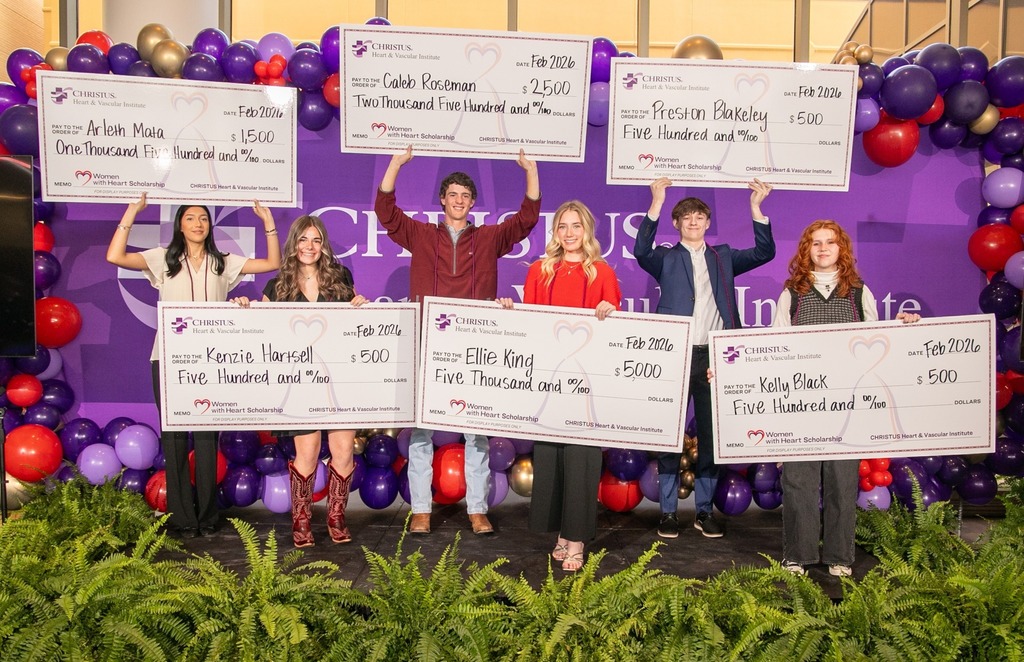 Caleb Roseman and other high school students holding up their checks for their scholarship