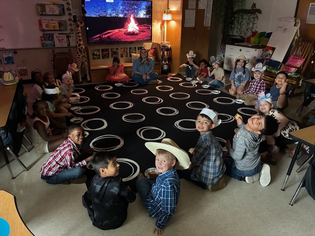 Kindergarten class gathered around a campfire eating chili.