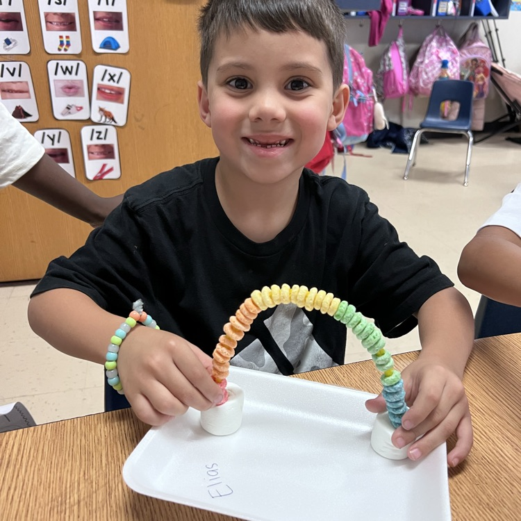 Student displaying their rainbow craft