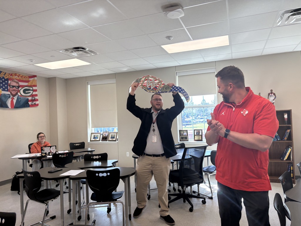 Tyler Legacy math teacher, Mr. Loeffler holding up the championship belt with Mr. Sherman clapping
