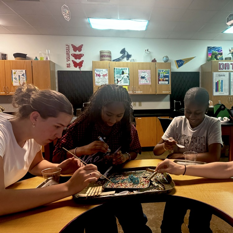 students engaged in a lab simulation at the teacher table 