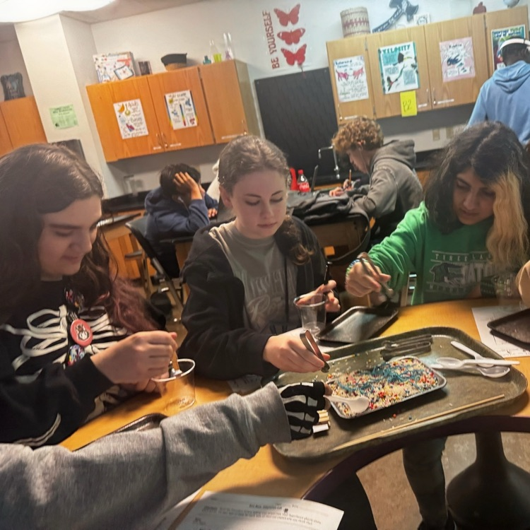 students engaged in a lab simulation at the teacher table 