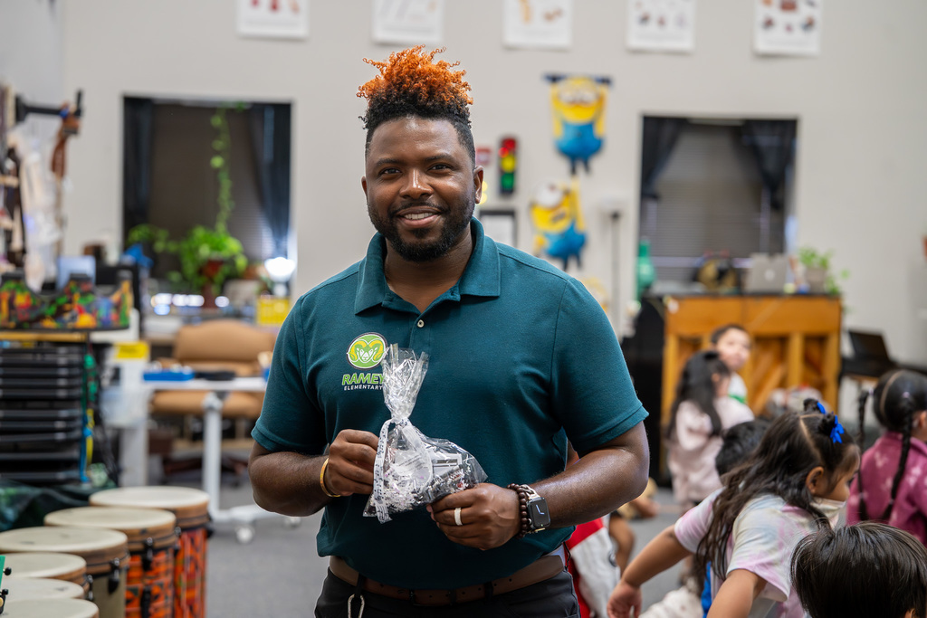 Ramey Music Teacher smiles while holding the WSL appreciation goodie bag.