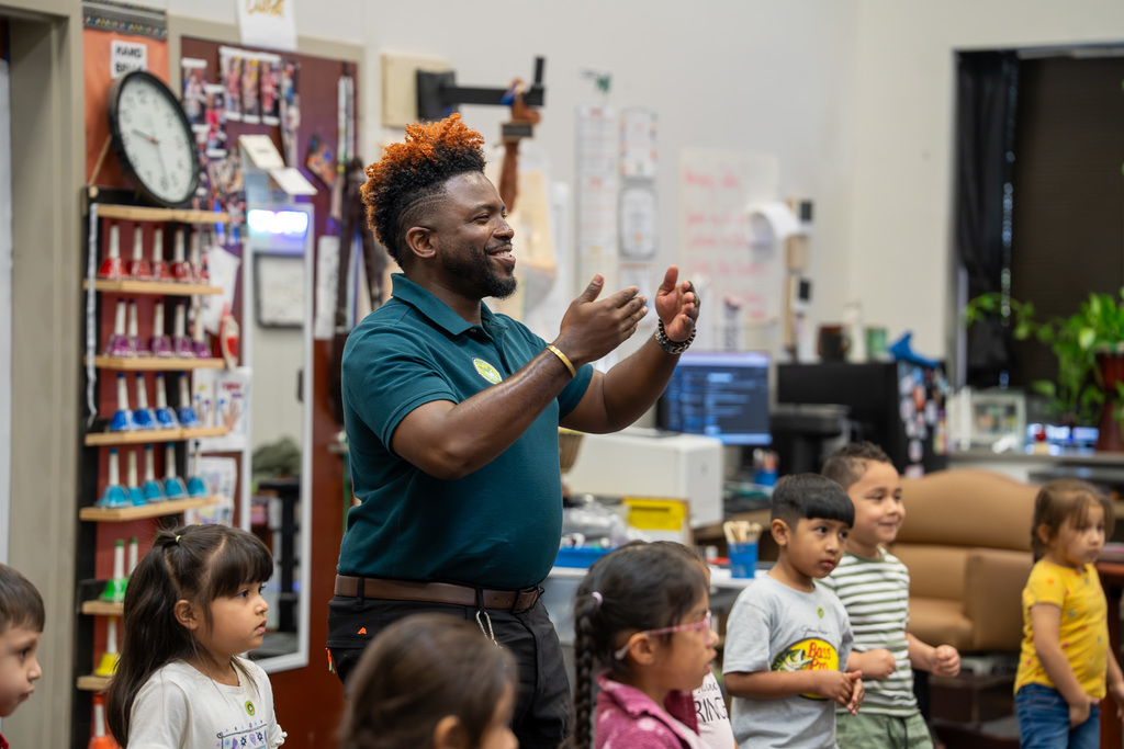 Ramey Music Teacher smiles with students as they learn about music in class.