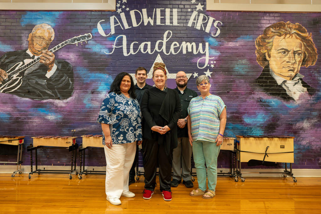 Caldwell Music Teachers smile in front of the Caldwell Arts Academy music mural.