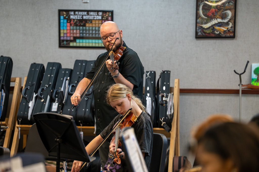 Caldwell Music Teacher plays the violin alongside a student while they learn a song.