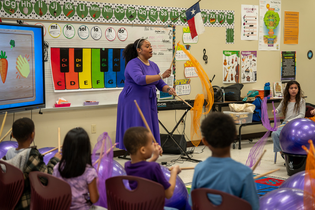 Dixie Music Teacher demonstrates how to drum in music class.