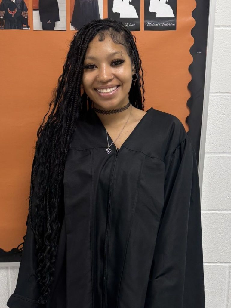 Student posing in graduation regalia