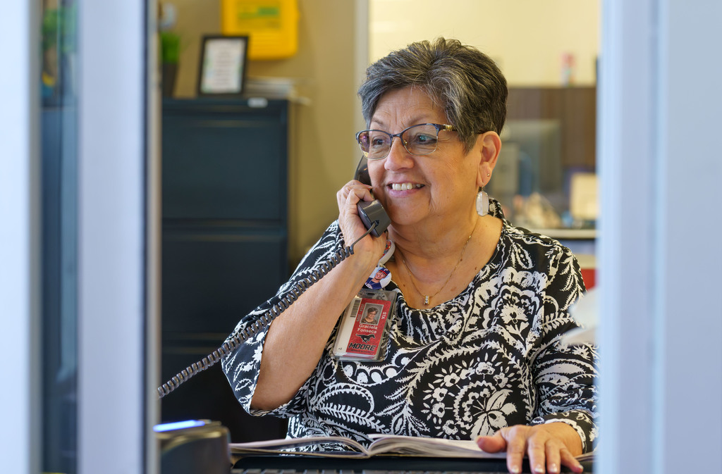 Tyler ISD Paraprofessional smiles while on the phone.