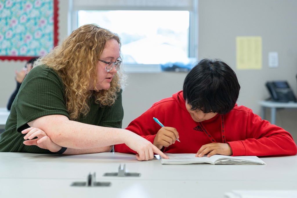 Tyler ISD Paraprofessional helps student with work.