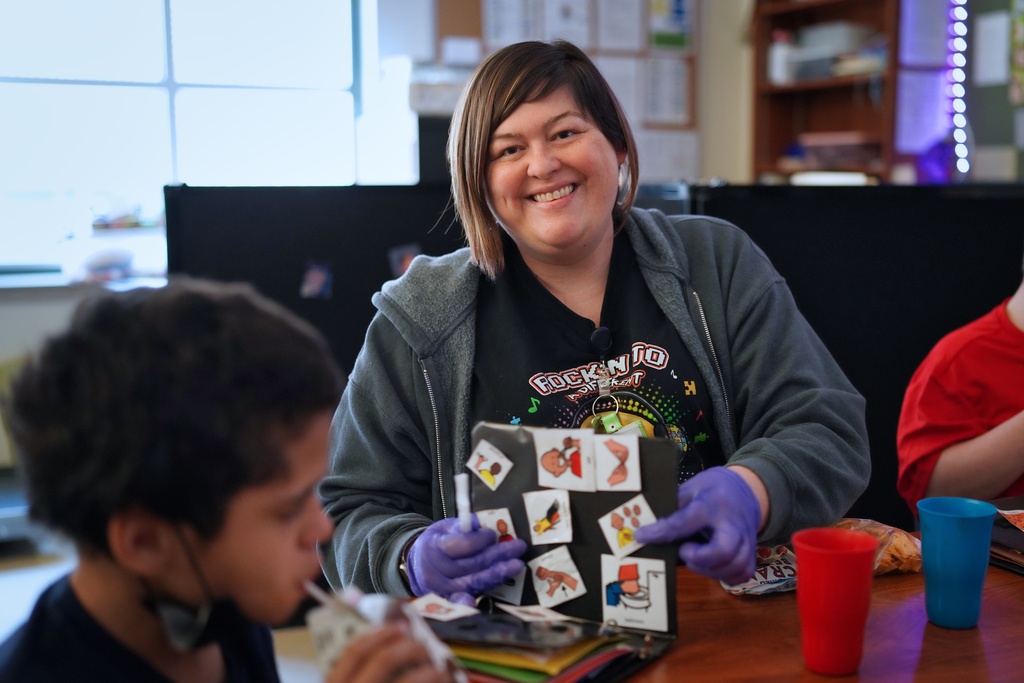 Tyler ISD Paraprofessional smiles while helping a student.