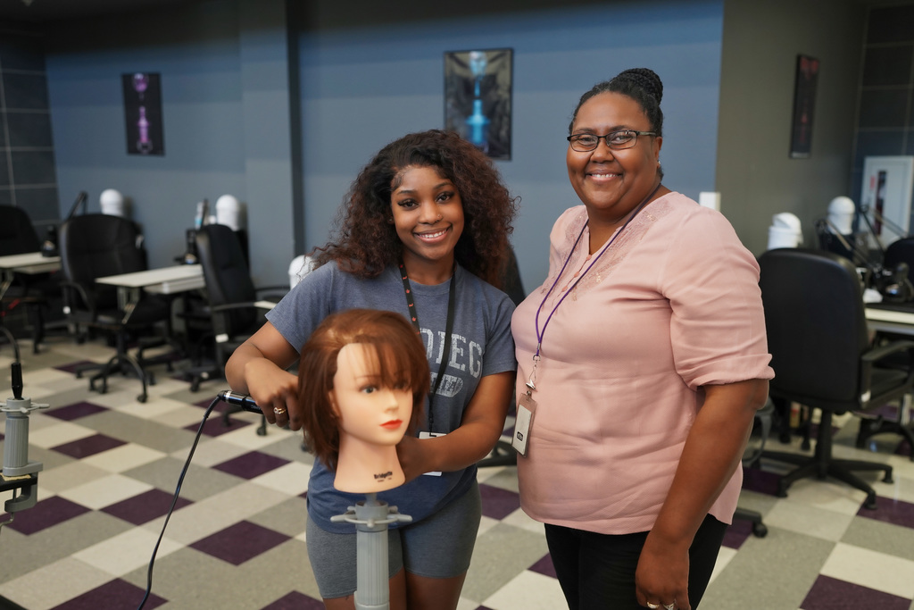 Tyler ISD Paraprofessional smiles with cosmetology student.