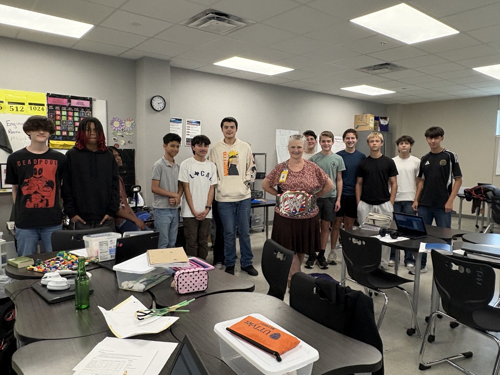 Tyler legacy's Walk Through Wednesday champion Mrs. McGough holding the champion belt with one of her classes