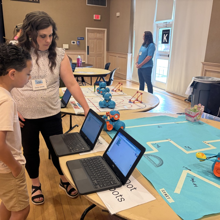 teacher teaching student how to code robot