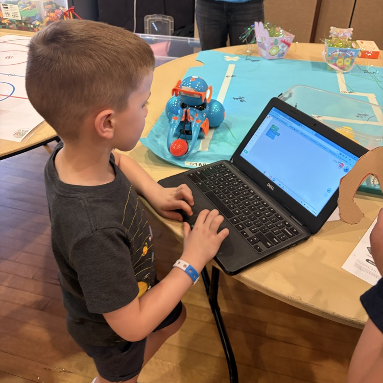 Student coding a robot with a laptop
