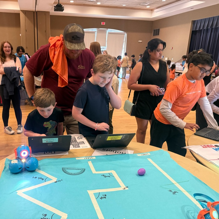 Students coding robots with a laptop