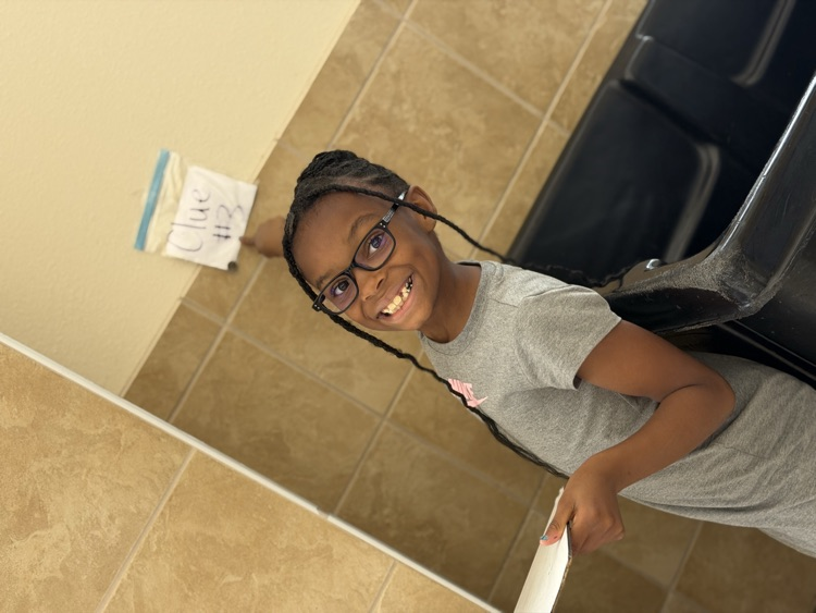 student smiling and pointing at clue