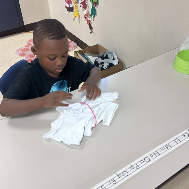 student lying up a shirt to dye 