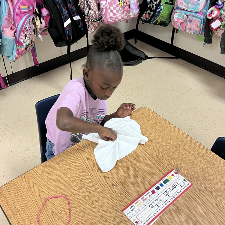 student lying up a shirt to dye 