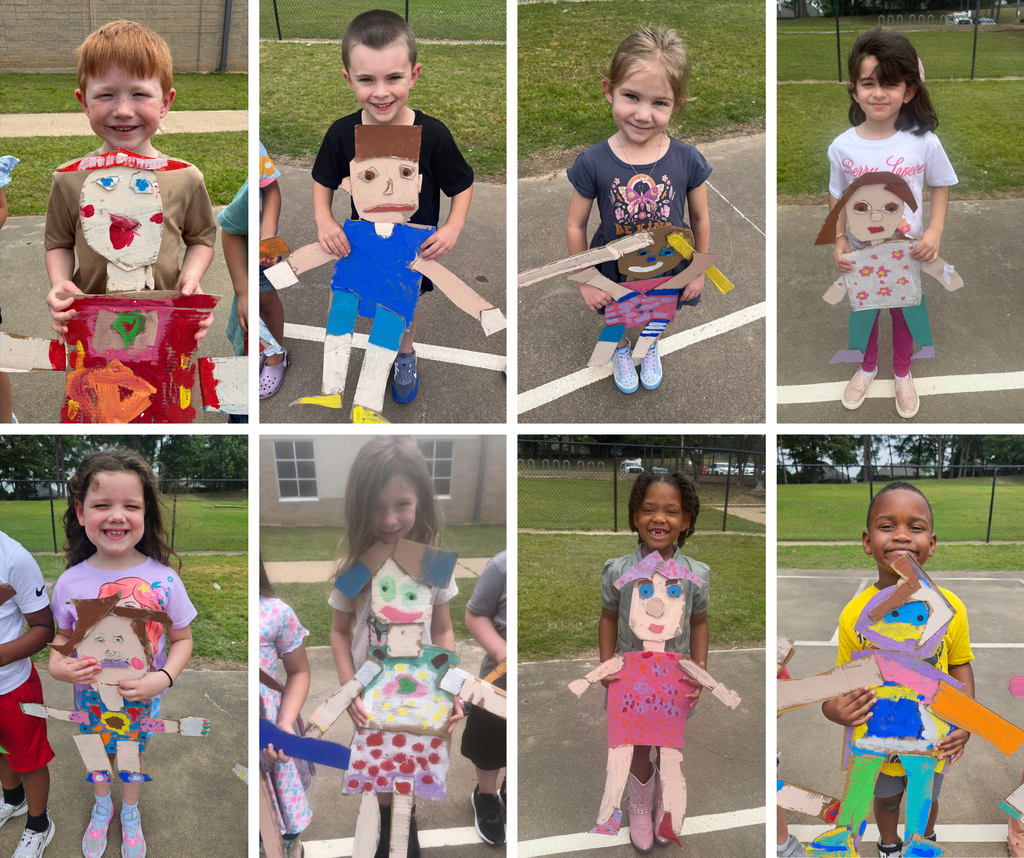Kindergarten students holding their carboard "mini me's."