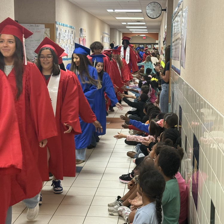 graduating seniors in their cap and gown walking hallways 