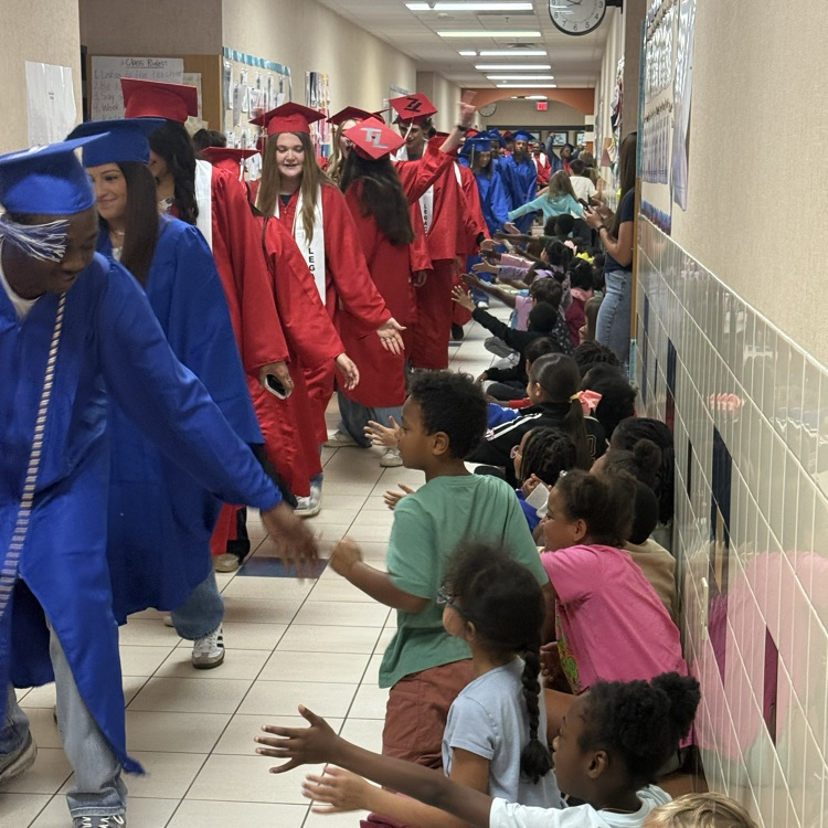 graduating seniors in their cap and gown walking hallways 
