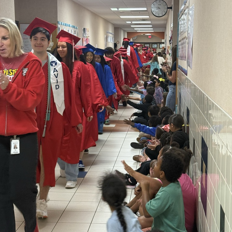 graduating seniors in their cap and gown walking hallways 