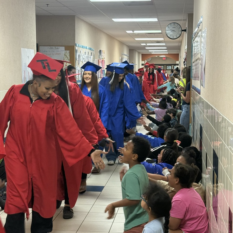 graduating seniors in their cap and gown walking hallways 