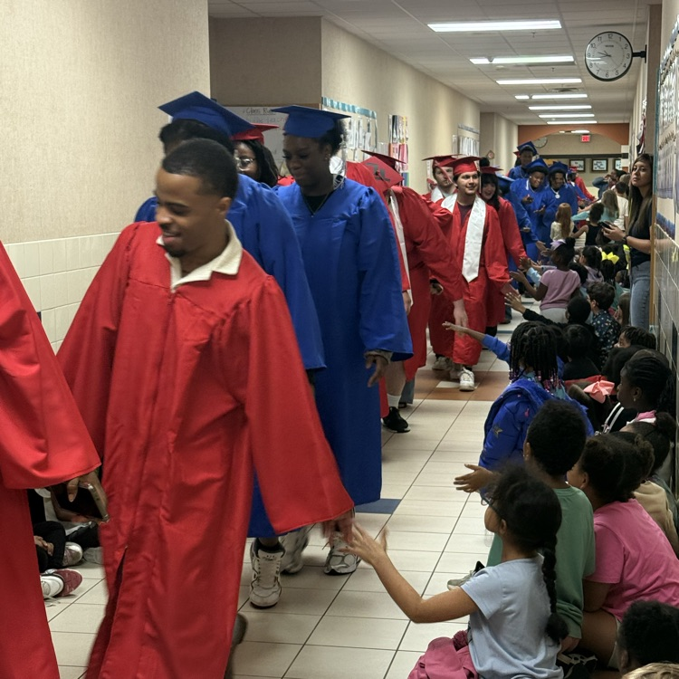 graduating seniors in their cap and gown walking hallways 
