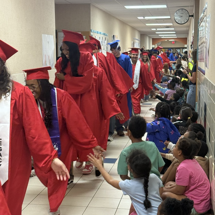 graduating seniors in their cap and gown walking hallways 
