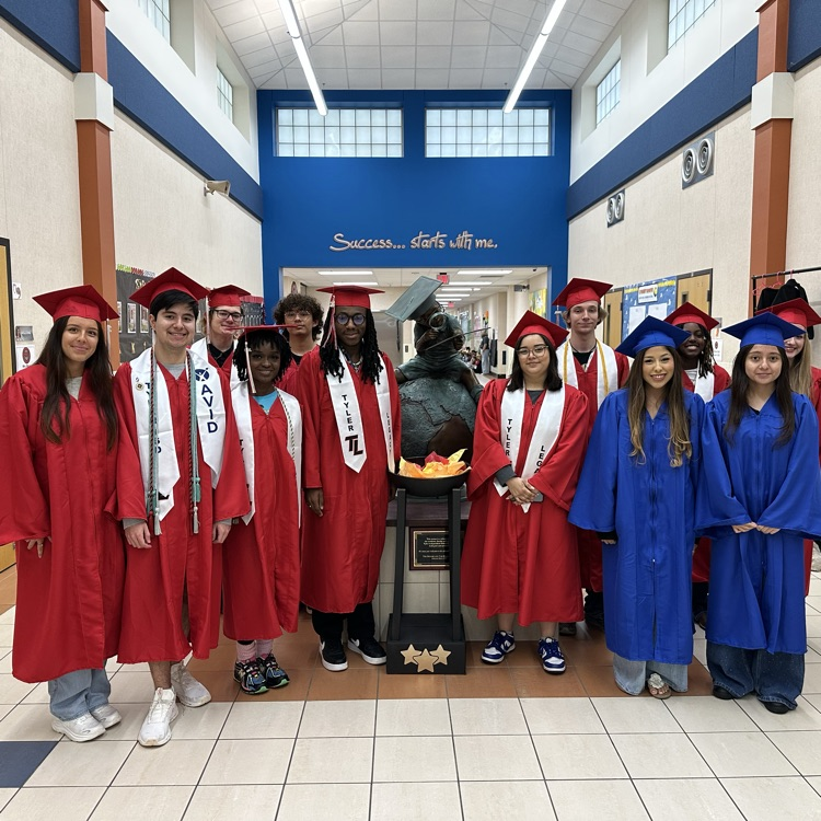 graduating seniors in their cap and gown walking hallways 