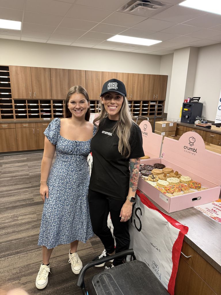 Tyler ISD staff member with a Crumbl cookies worker and cookies in the background