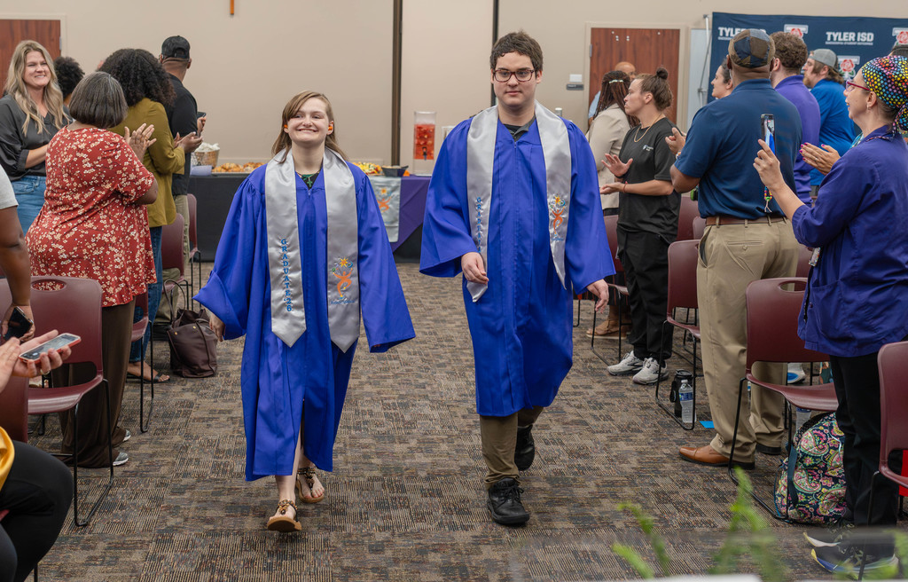 Two Project SEARCH graduates smiling and walking side-by-side.