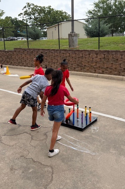 four kids playing ring toss