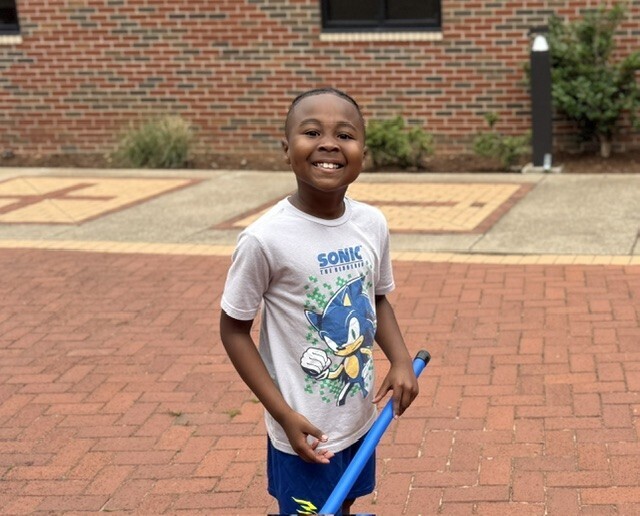 one boy smiling holding a baton