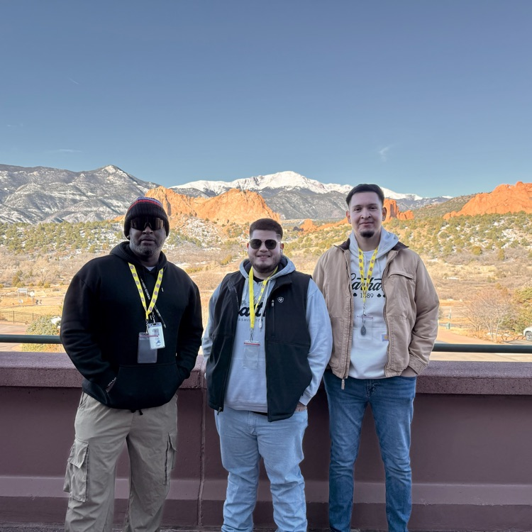 three men in front of a mountain
