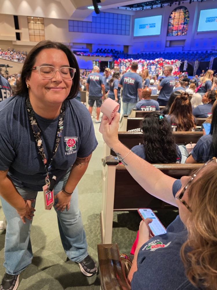 teachers sitting at convocation with a fan