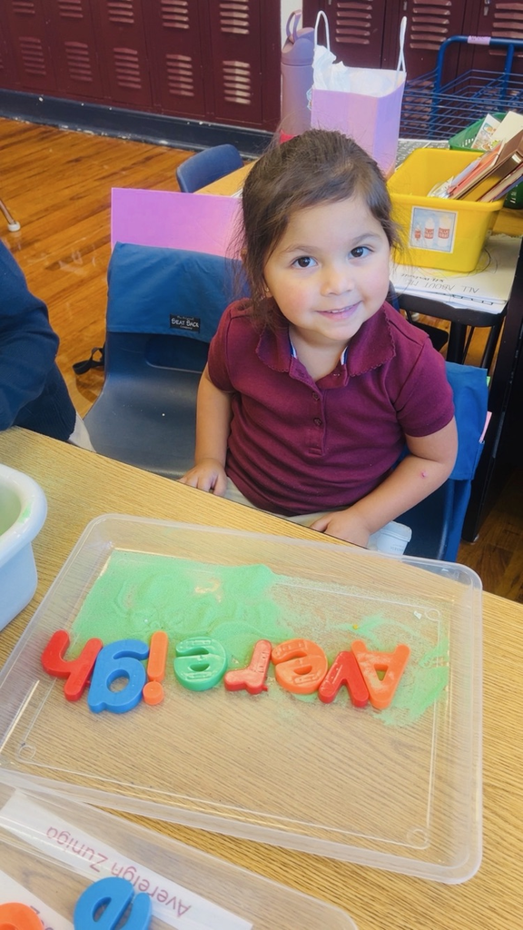 child at table with letters