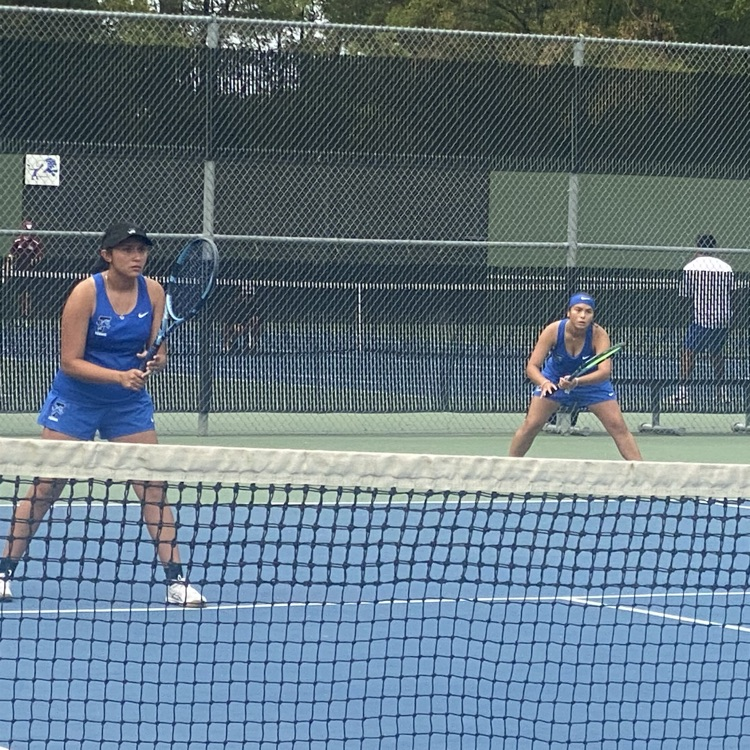 tennis doubles team on court waiting on serve