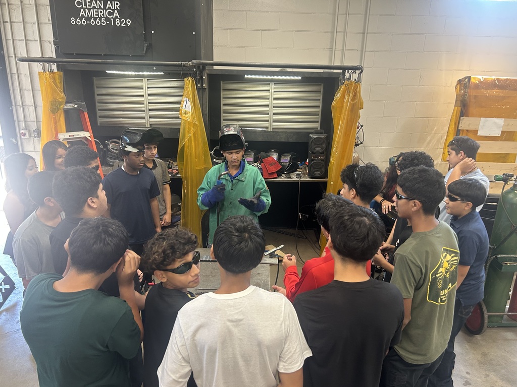 one student teaching a group about welding